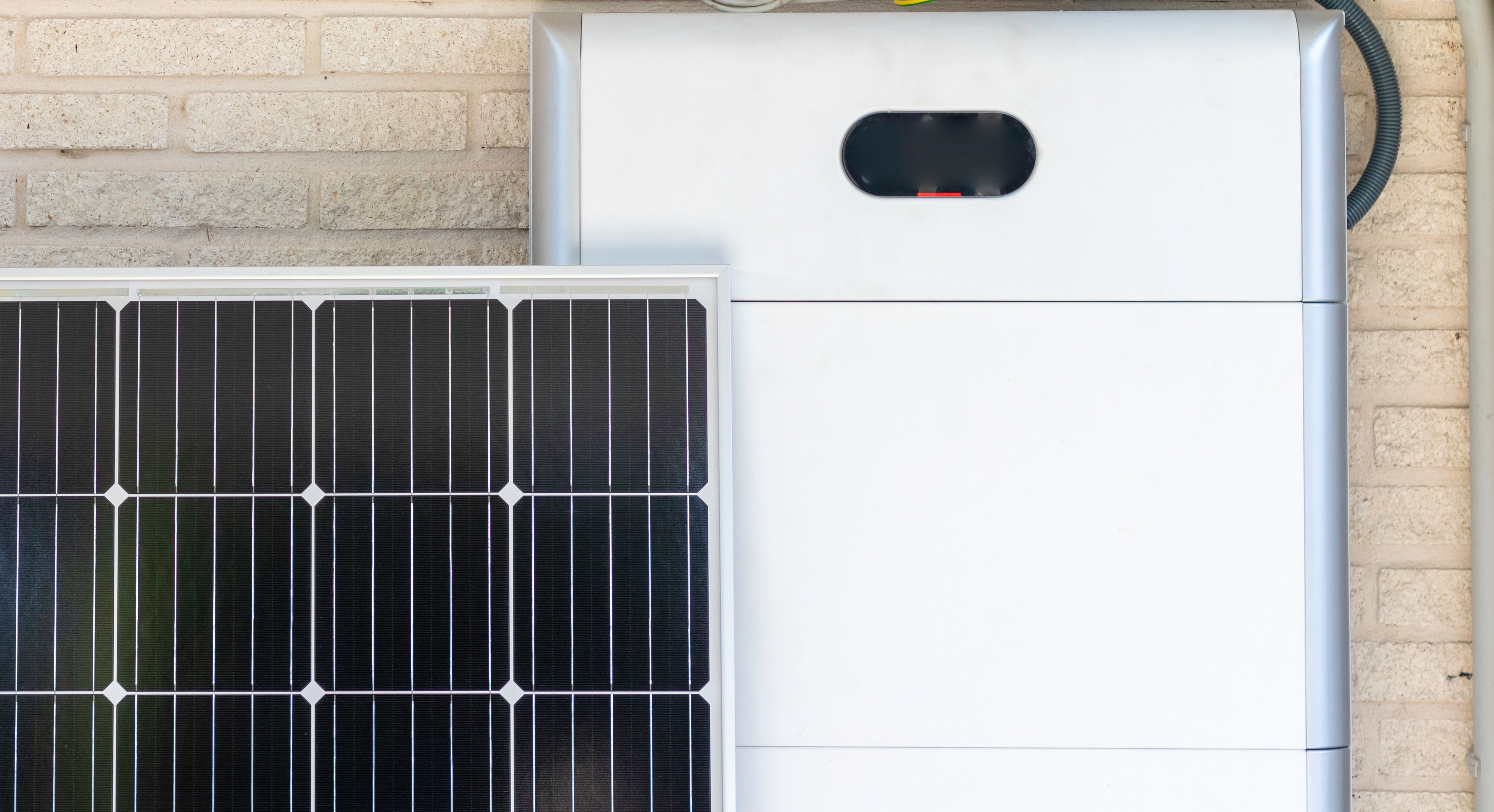 Front view of photovoltaic panel and battery instalation leaning on the beige white wall with no people renewable energy | © NOWRA photography / Adobe Stock