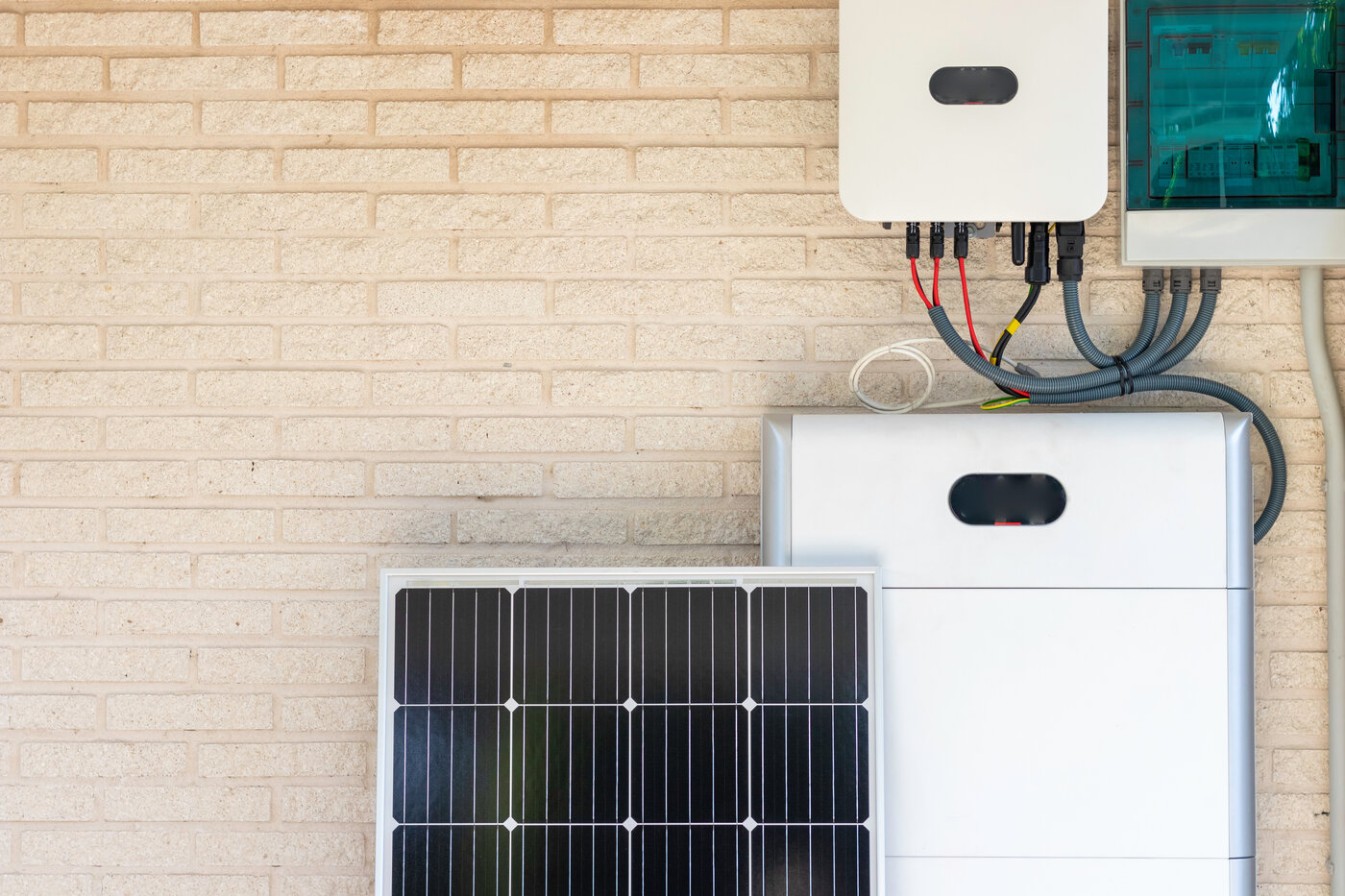 Front view of photovoltaic panel and battery instalation leaning on the beige white wall with no people renewable energy | © NOWRA photography / Adobe Stock