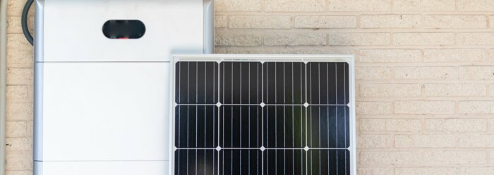 Front view of photovoltaic panel and battery instalation leaning on the beige white wall with no people renewable energy | © NOWRA photography / Adobe Stock