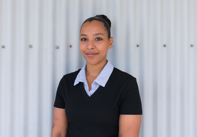 Hanane Carluccio | © Swissolar Frau mit schwarzem Oberteil und grauem Hintergrund | © Swissolar