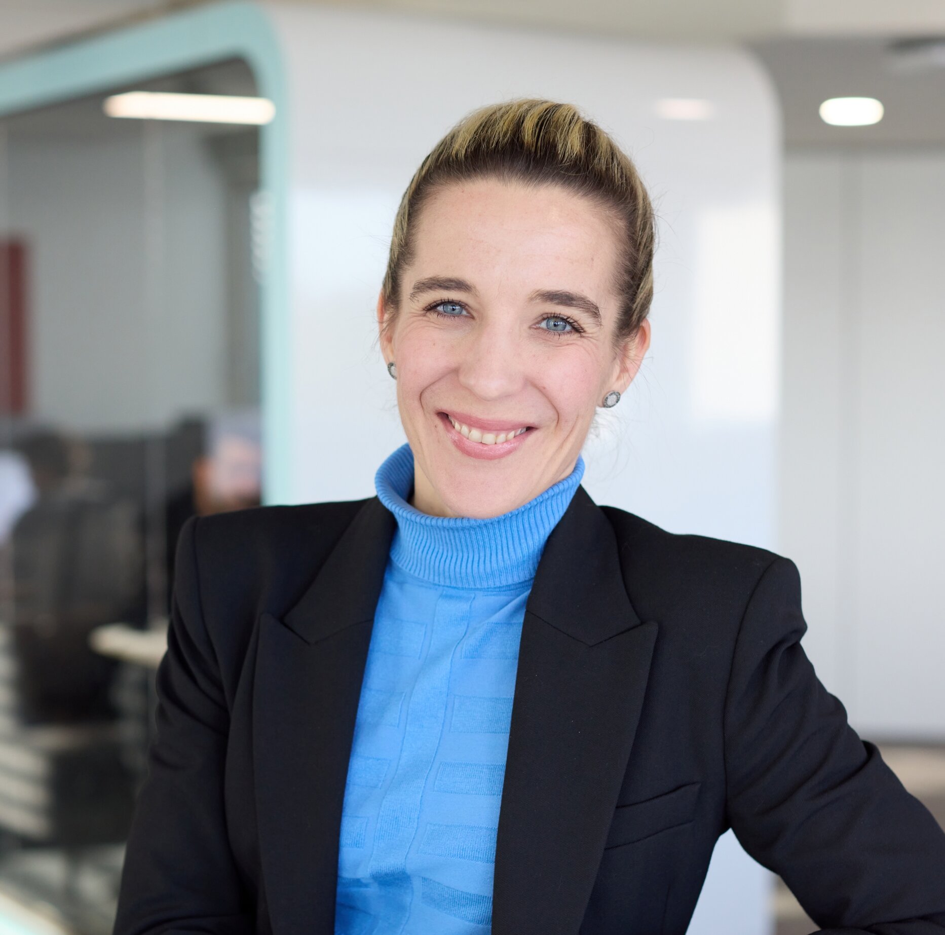 Frau mit blonden Haaren, blauen Shirt und schwarzen Jacket | © Aurore Amaudruz