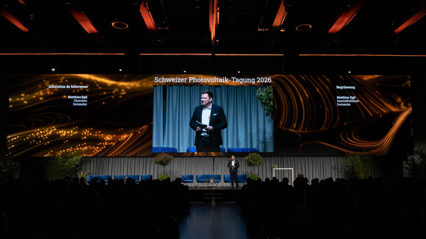 Mann auf Bühne einer Veranstaltung. Schwarzer Hintergrund.  | © © Swissolar / Sarah Bollmann